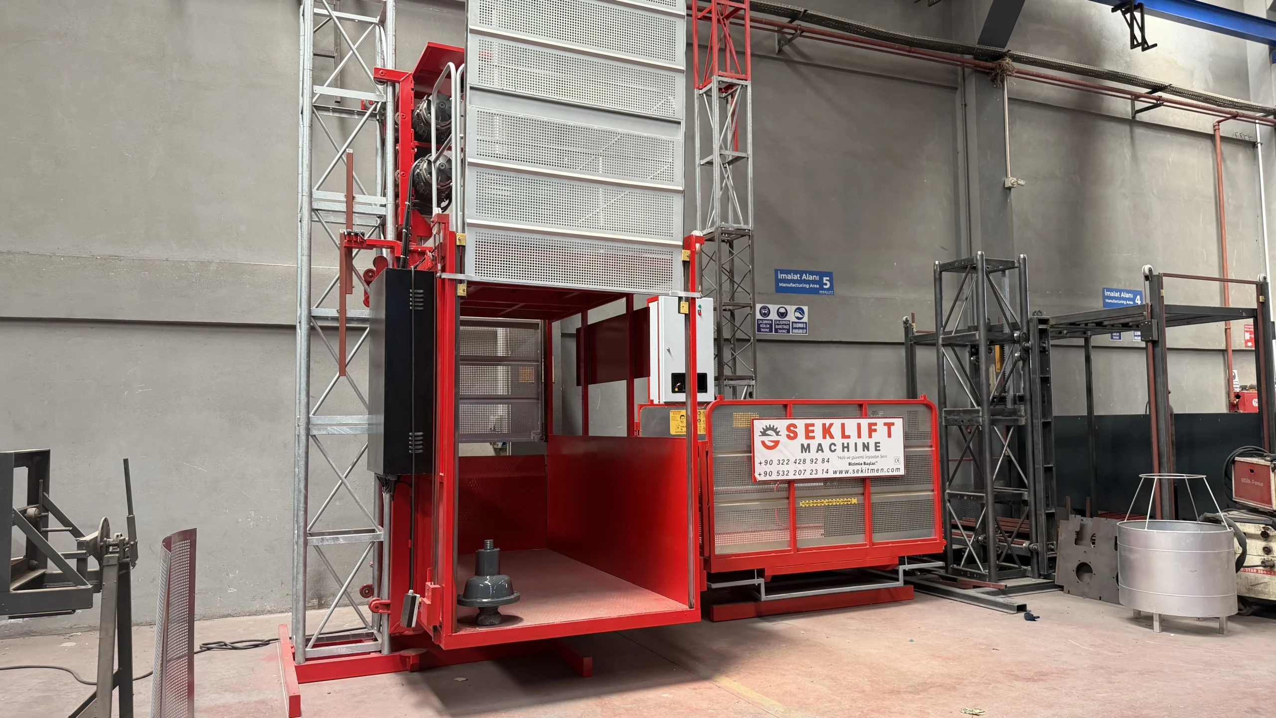 SEKLIFT SM-GTP-103 and SM-GTP-101 construction hoists displayed in the manufacturing facility