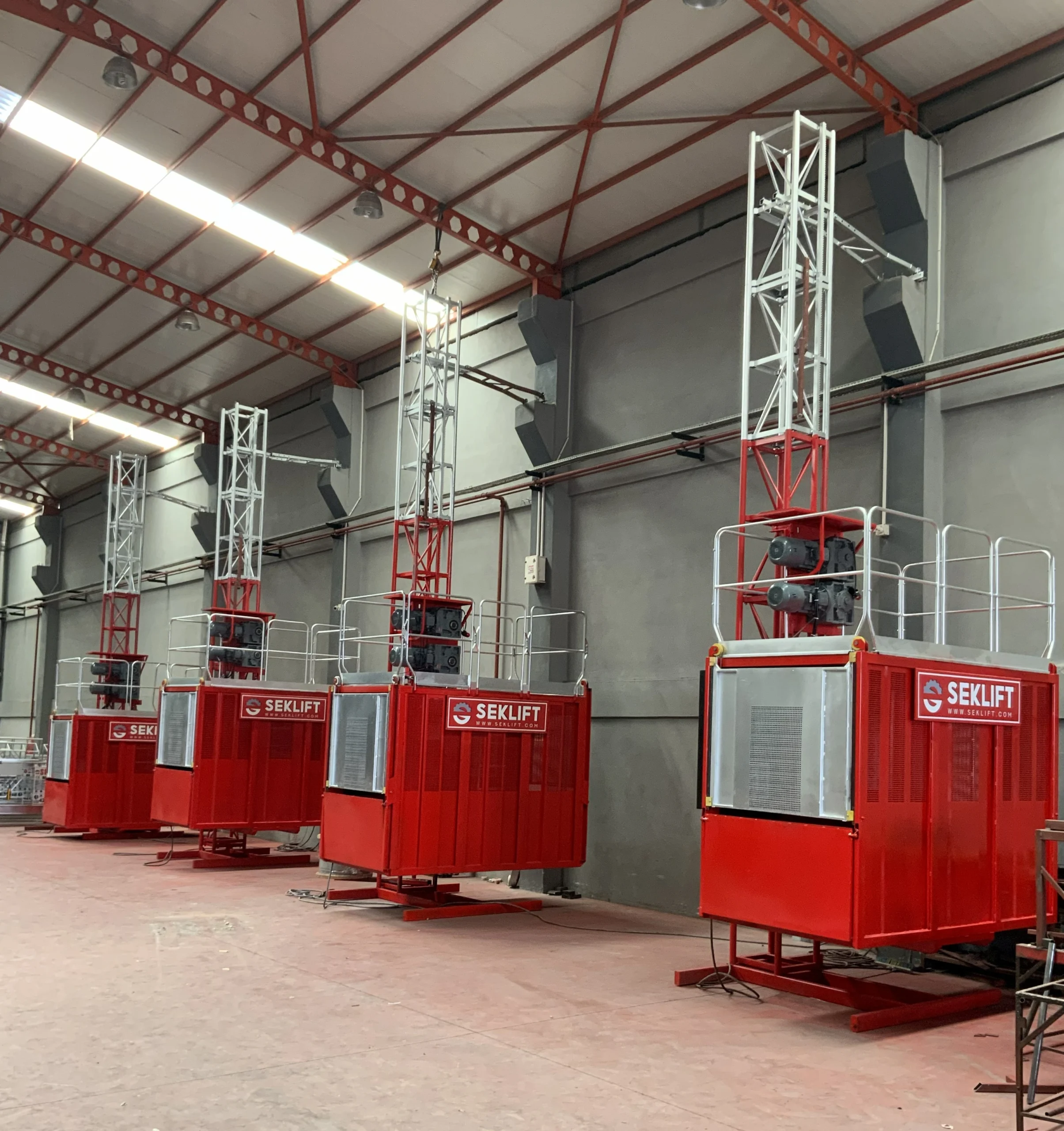 SEKLIFT vertical access equipment manufacturer's rack-and-pinion construction hoist installed inside an industrial building for vertical personnel and material transport