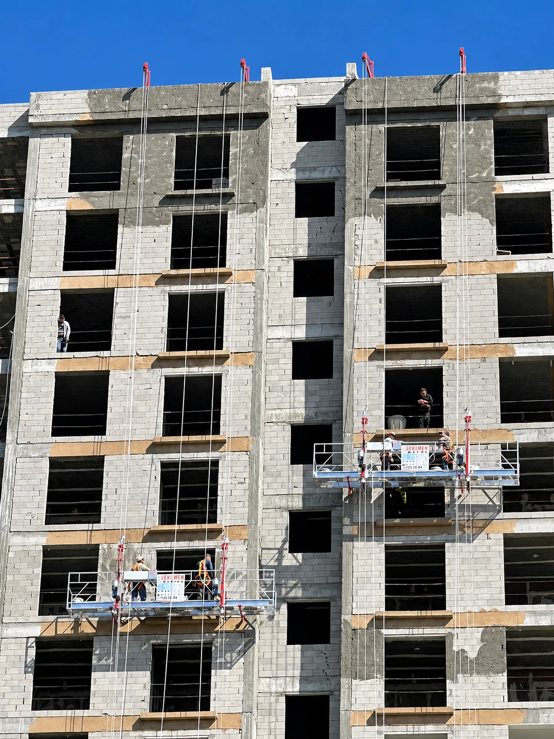 SEKLIFT electric suspended platforms operating on a multi-storey construction façade
