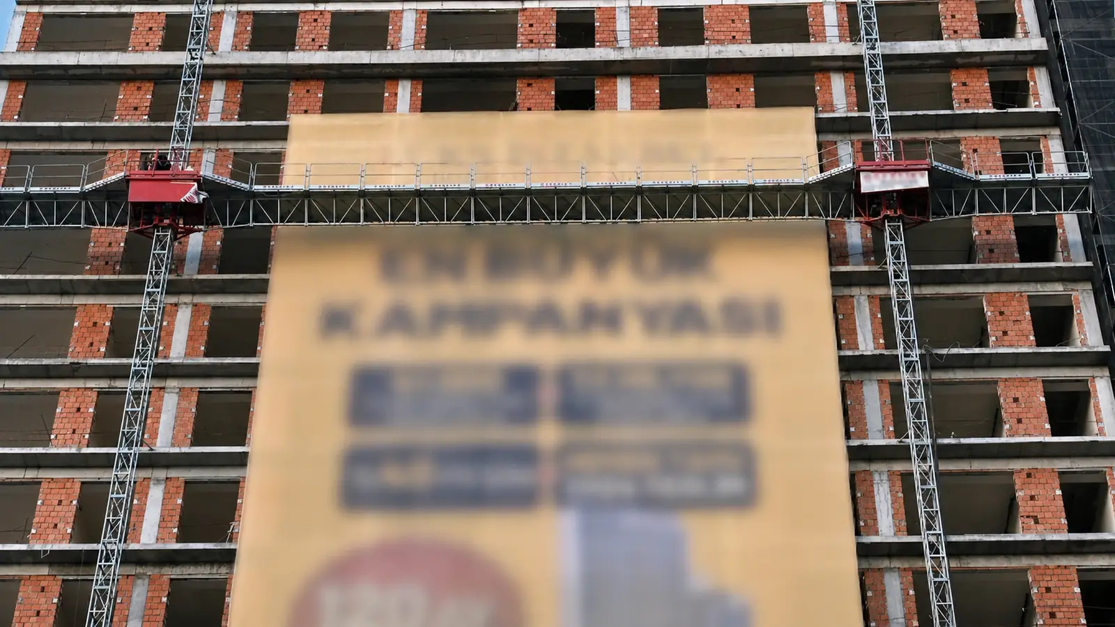 Plataforma de trabalho suspensa por mastros duplos SEKLIFT SM-SK-102 instalada na fachada de uma construção de vários andares